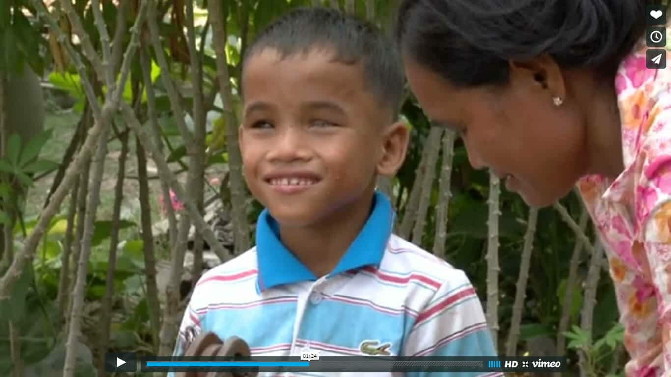 Video: a smiling boy looks up at his mother in a garden, sharing a warm moment together