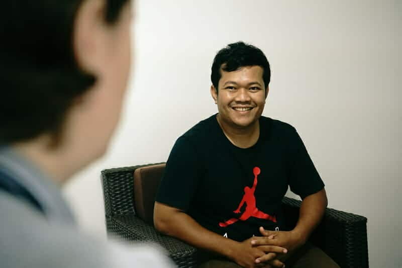 Menghong smiles while talking with a colleague during an interview about his work keeping children in families