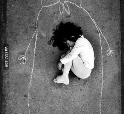 Child curled up on pavement inside a chalk outline of a larger figure holding a flower